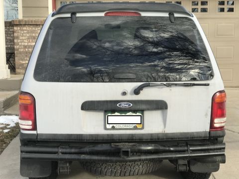 2000 Ford Explorer - The rear of a white 2000 Ford Explorer is shown, its license plate and spare tire.