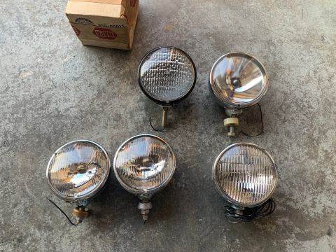 1993 Ford Bronco - A collection of vintage headlights and a NAPA parts box are laid out on a concrete surface.