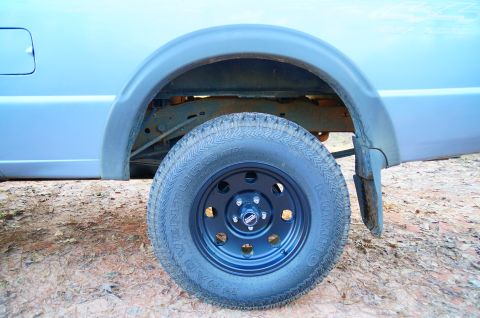 1998 Ford Ranger - Close-up of a truck's rear wheel and fender flare, showing the tire and suspension components.