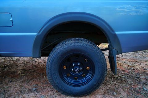 1998 Ford Ranger - Close-up of a blue pickup truck's rear wheel and fender.