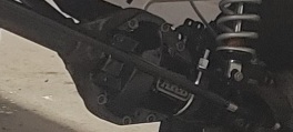 1996 Ford Bronco - A close-up view of the rear differential housing and suspension components of a vehicle, possibly a Ford Bronco, showing a black differenti…