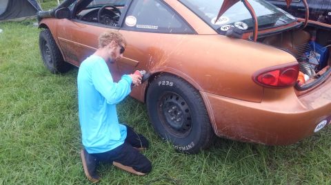 1990 Ford F-250 - using an angle grinder to gain some more wheel clearance in his Chevy Cavalier