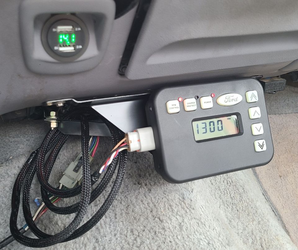 Ford trailer brake controller with '1300' displayed, next to a dual USB charger showing '14.1'