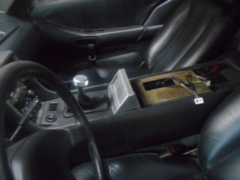 1992 Ford Bronco - The interior of a vehicle is shown, focusing on the center console and dashboard area. Visible components include a steering wheel, gear sh…
