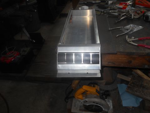 1992 Ford Bronco - A metal console with four buttons is shown on a workbench. Tools and a circular saw are visible in the background.