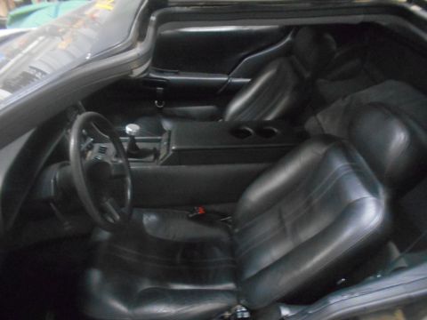 1992 Ford Bronco - The interior of a black leather car, featuring bucket seats, a steering wheel, and a center console with cup holders. The view is from the…