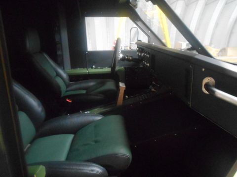 1992 Ford Bronco - The interior of a vehicle shows two-tone black and green leather seats, a dashboard with various gauges and switches, and a steering wheel.…