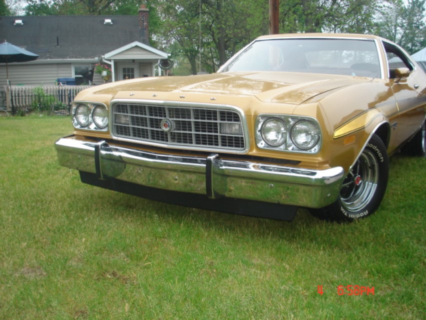 Gold 1976 Ford Ranchero front quarter view, parked on grass.