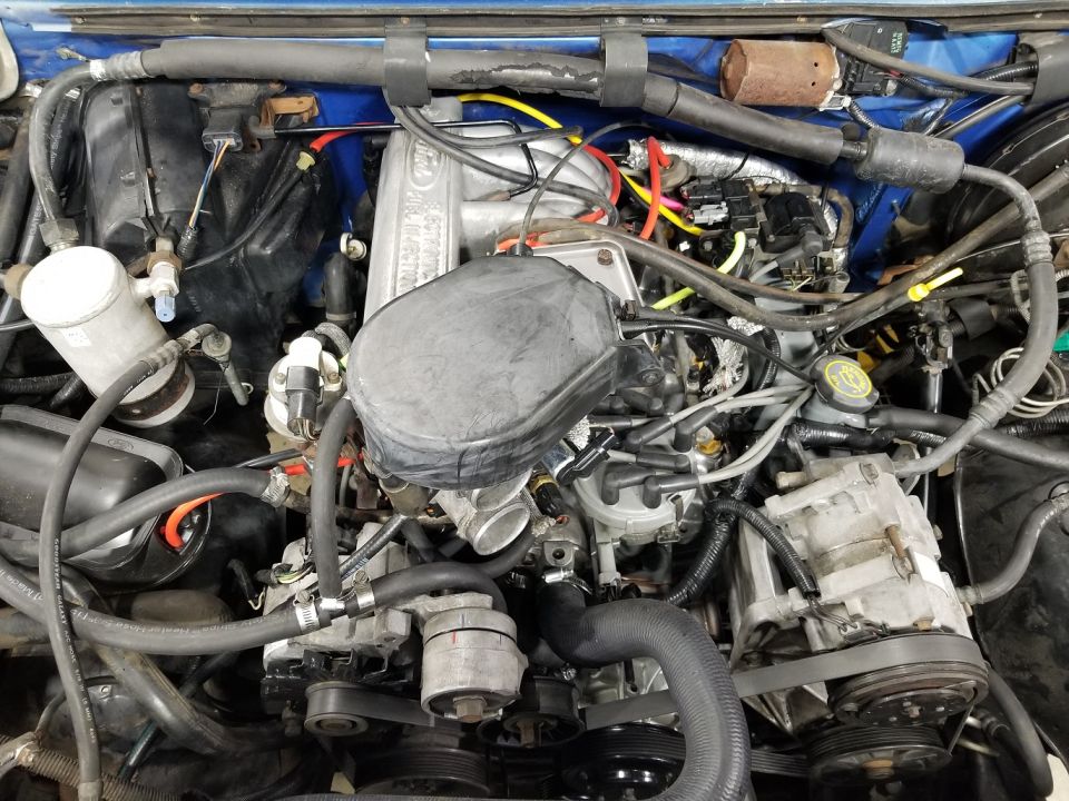 Ford engine bay with oil-bath air cleaner and blue painted firewall