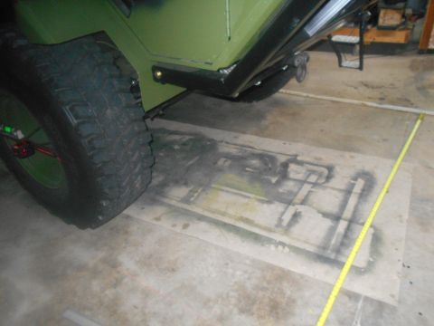 1992 Ford Bronco - A close-up view of the rear tire and fender of a green vehicle, possibly a Ford Bronco, with a yellow measuring tape positioned on the grou…