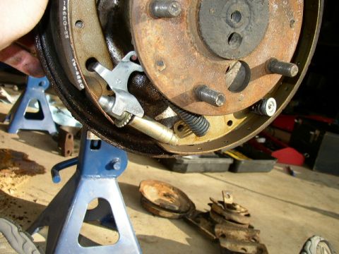 1995 Ford Bronco - Brake drum and shoes are shown disassembled and supported by jack stands.
