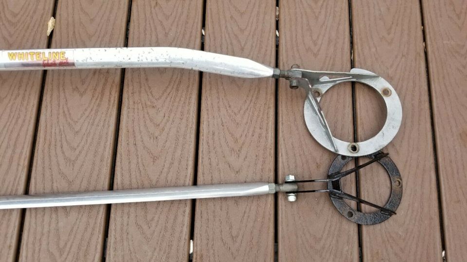 Whiteline strut bar with mounting hardware on wooden deck
