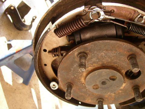 1995 Ford Bronco - Close-up of a vehicle's brake drum assembly, showing internal components like springs and brake shoes.