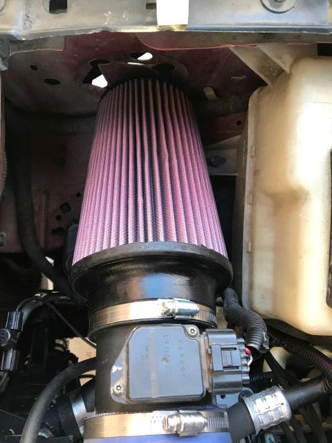 2000 Ford Explorer - A close-up view of a custom engine air intake system in a vehicle, featuring a conical purple air filter connected to a mass airflow sensor.