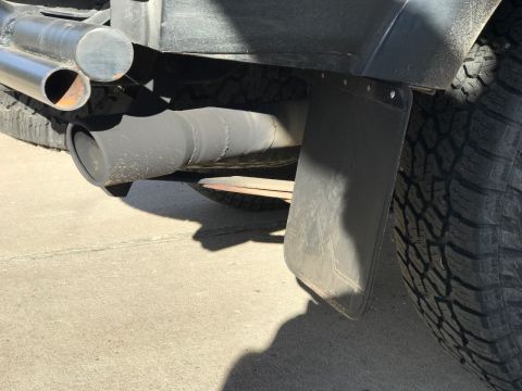 2000 Ford Explorer - Vehicle exhaust pipe and mud flap shown from the rear corner.