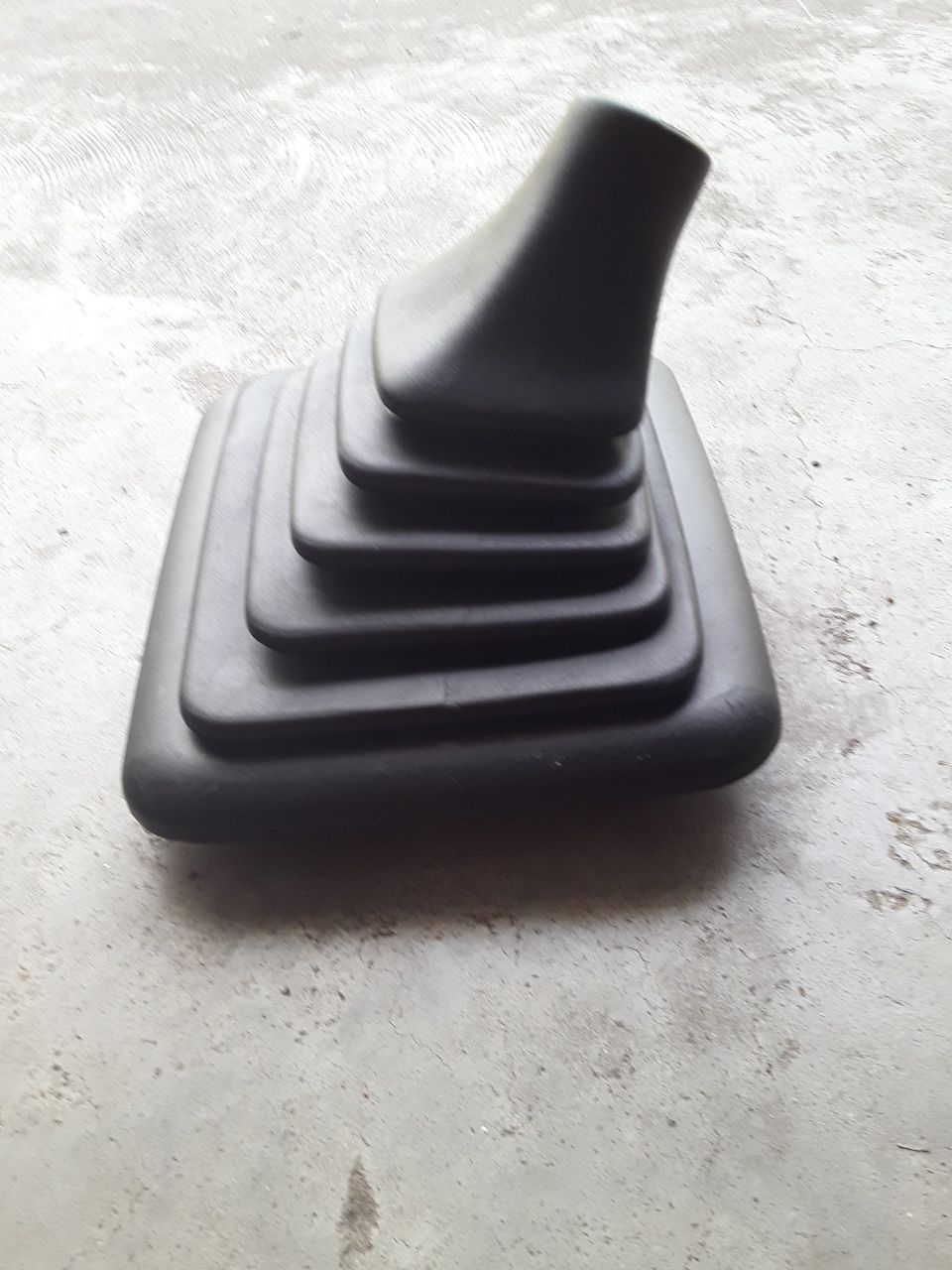 Black rubber shift boot with pleats on concrete
