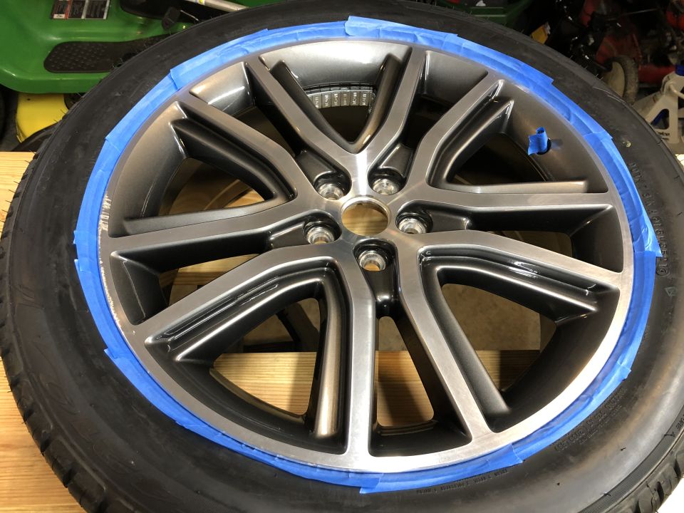 Car wheel with blue painter's tape around the rim.