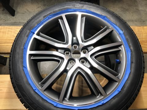 2019 Ford Everest - A close-up of a gray alloy wheel with a tire, masked with blue painter's tape around the outer edge. The wheel has a multi-spoke design wit…