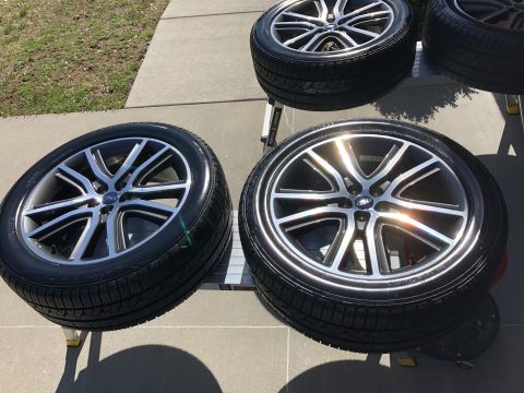 2019 Ford Everest - Four clean, shiny aftermarket wheels with tires are displayed on a sunny day, likely after being washed. The wheels have a silver and black…
