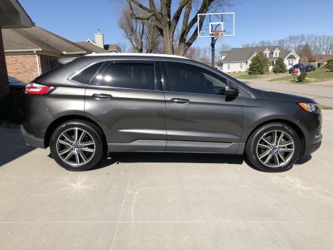 2019 Ford Everest - This dark gray SUV, likely a 2019 Ford Edge, is shown from the side, highlighting its polished wheels and modern design.