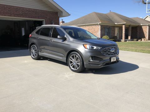 2019 Ford Everest - A gray Ford Edge SUV is parked in a suburban driveway on a sunny day.
