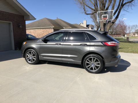2019 Ford Everest - Side view of a gray 2019 Ford Edge SUV parked on a concrete driveway.
