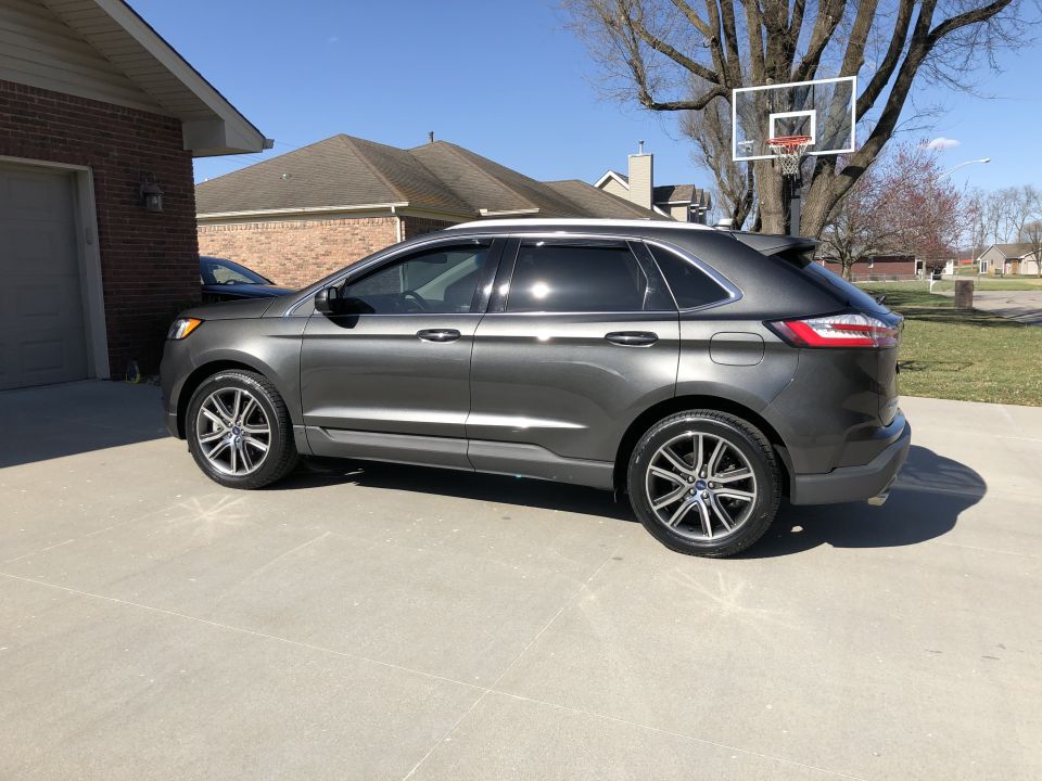 Gray 2019 Ford Edge parked in driveway next to brick house