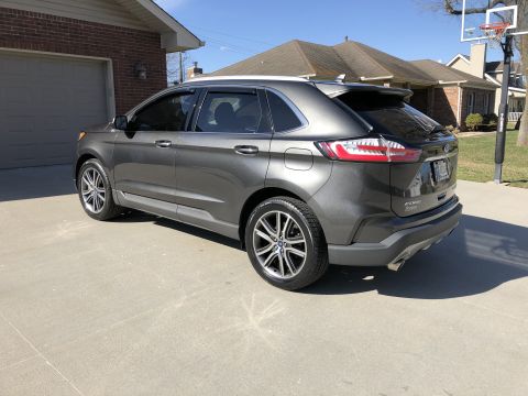 2019 Ford Everest - This Ford Edge SUV is parked in front of a brick house with a garage and a basketball hoop.