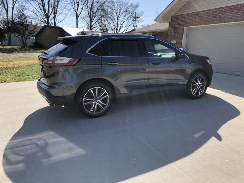 2019 Ford Everest - Side view of a dark gray 2019 Ford Edge SUV parked on a concrete driveway.
