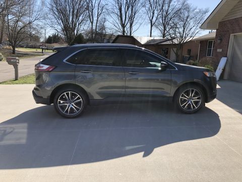2019 Ford Everest - A dark gray Ford Edge SUV is parked in a residential driveway on a sunny day.
