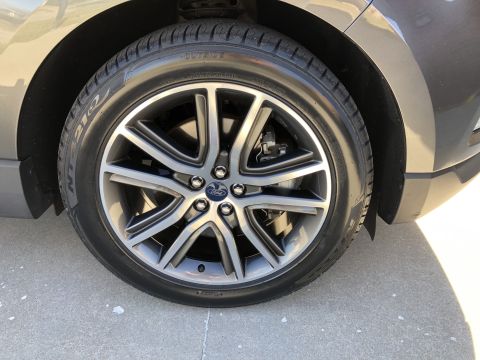 2019 Ford Everest - Close-up of a polished Ford wheel and tire on a dark gray SUV.