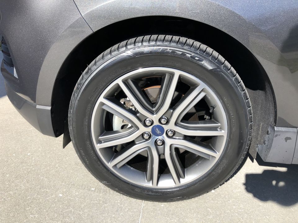 Gray SUV wheel with polished multi-spoke rim and Ford logo