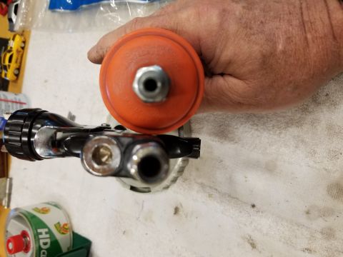 1973 Chevrolet Camaro - A close-up view of a spray gun and its attached regulator, with a toy car in the background.