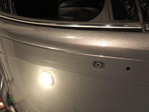 2019 Ford Everest - Close-up of a vehicle's rear bumper shows a parking sensor and a mounting hole.