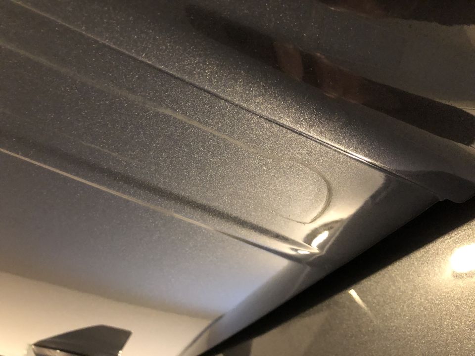 Gray metallic roof rack mounting point with embossed lines