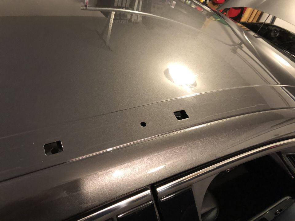 Close-up of a car's roof with mounting points for a roof rack