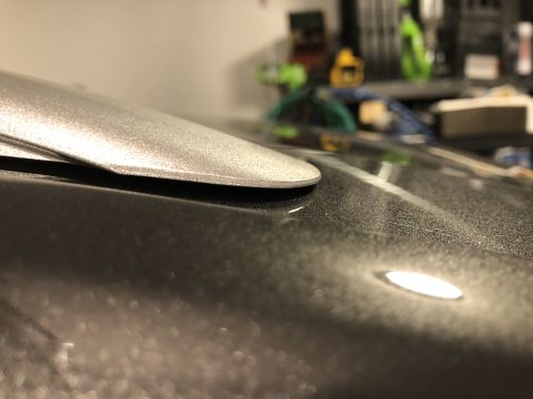 2019 Ford Everest - Close-up of a silver roof rack rail edge on a dark gray speckled car roof.