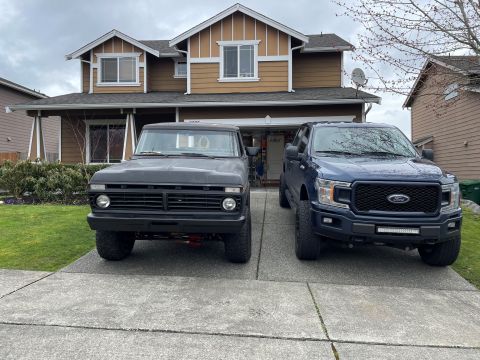 1978 Ford Bronco - Two Ford trucks, one vintage and one modern, parked in front of a suburban house.