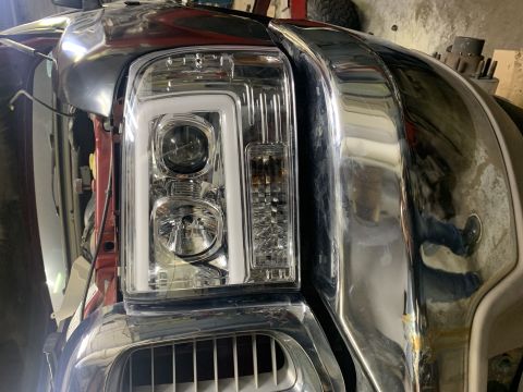 2002 Ford Excursion - Close-up of the front end of a large SUV, a chrome grille and updated headlights. The registry claims it is a 2002 Ford Excursion, but the…