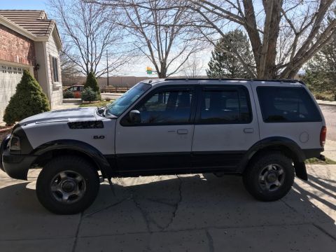 2000 Ford Explorer - This 2000 Ford Explorer is seen from the side, parked in front of a house.