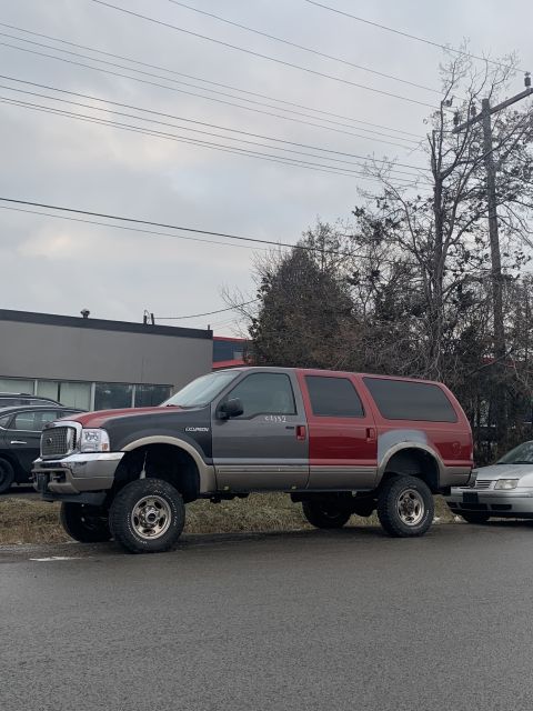 2002 Ford Excursion - This lifted two-tone Ford Excursion is seen from the side, showing its substantial height and two-color paint scheme.