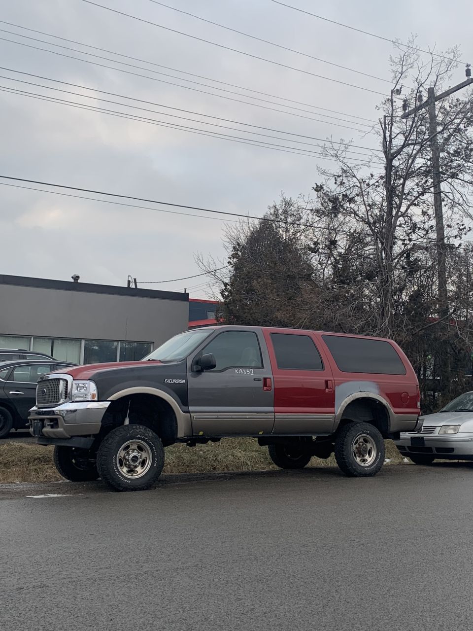 Lifted two-tone SUV side view. 2002 Ford Excursion