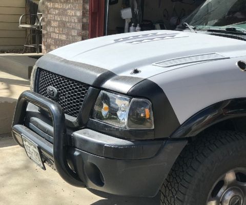 2000 Ford Explorer - Front view of a white pickup truck, a bull bar and a distinctive honeycomb grille. The year is estimated to be around 2000.
