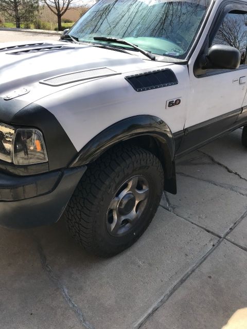 2000 Ford Explorer - Close-up view of the front passenger side of a Ford Explorer, highlighting its wheel and fender details.