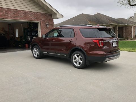 2016 Ford Explorer - A maroon Ford Explorer is parked in front of a garage and house.