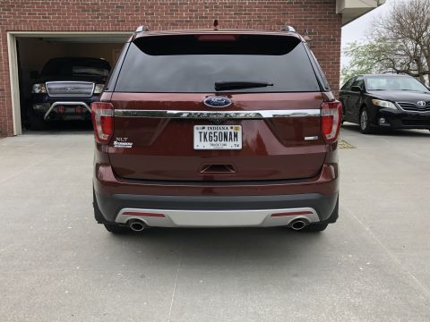2016 Ford Explorer - The rear of a maroon Ford Explorer is shown, with other vehicles visible in the background and garage.