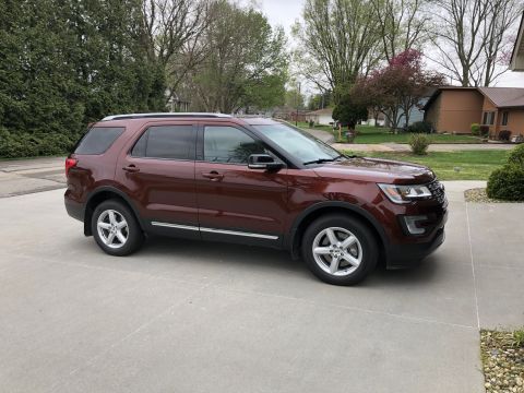 2016 Ford Explorer - A brown 2016 Ford Explorer is parked on a concrete driveway in front of a residential house.