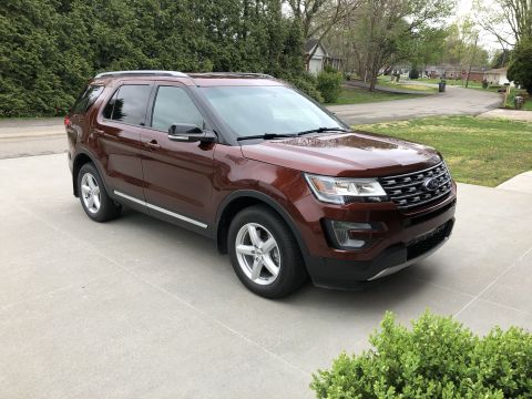 2016 Ford Explorer - A brown 2016 Ford Explorer is parked in a driveway, its front grille and headlights.