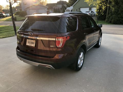 2016 Ford Explorer - The rear of a brown Ford Explorer SUV is visible, parked on a driveway with a basketball hoop in the background.