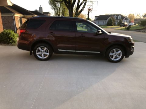 2016 Ford Explorer - A brown Ford Explorer is parked on a concrete driveway in front of a house.